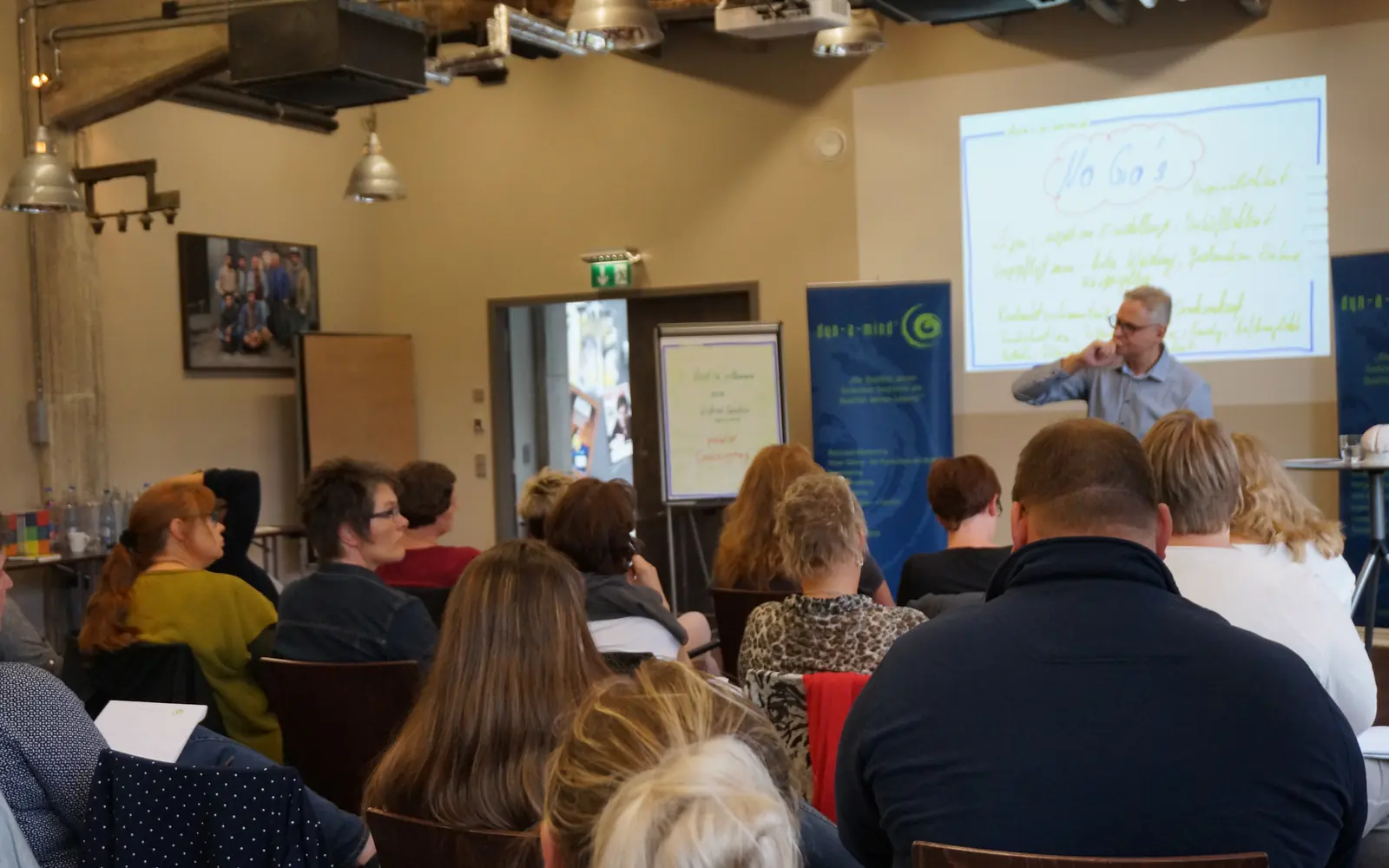 Seminarraum beim Finanz-Coaching, Teilnehmende und Flipchart